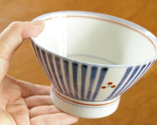 砥部焼・梅山窯　とくさみつ紋の茶碗を手に持って