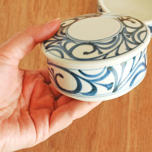 砥部焼・梅山窯　からくさの二段ふた物(小)を手に持って