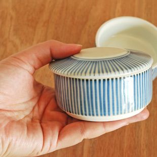 砥部焼・梅山窯　とくさ柄の二段ふた物(小)を手に持って