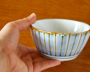 砥部焼・梅山窯　縞もようの台形鉢を手に持って