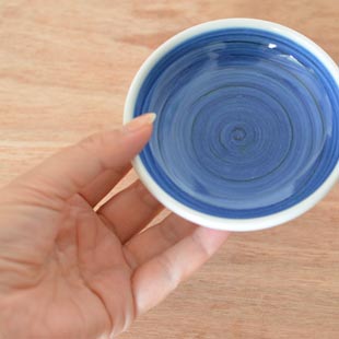 砥部焼・梅山窯　藍色の小皿(3.5寸)を手に持って
