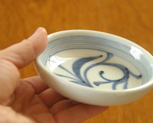 砥部焼・梅山窯　ひとつからくさの小皿（3,5寸）を手に持って