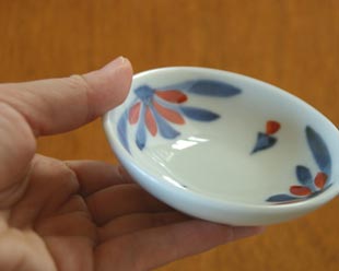 砥部焼・梅山窯　花もようの小皿（3寸）を手に持って