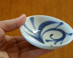 砥部焼・梅山窯　からくさの小皿（3寸）を手に持って