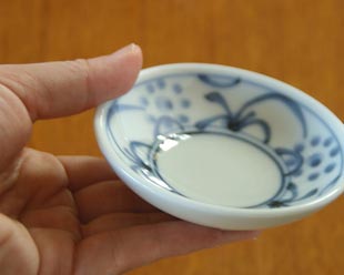 砥部焼・梅山窯　太陽柄の小皿を手に持って