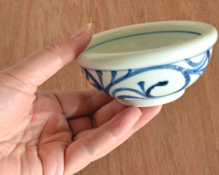 砥部焼・梅山窯 外からくさの玉ぶち鉢(3寸)を手に持って