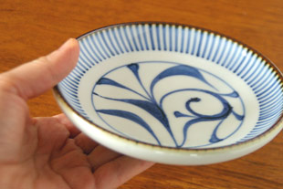 砥部焼・梅山窯　とくさ内唐草の取皿(4,6寸)を手に持って