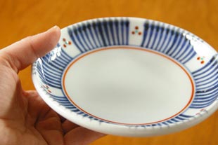 砥部焼・梅山窯　とくさみつ紋の取皿を手に持って