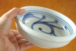 砥部焼・梅山窯　内からくさの半玉ぶち鉢を手に持って