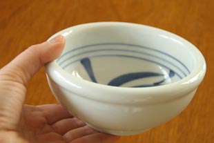 砥部焼・梅山窯　内からくさの玉ぶち鉢(4寸)を手に持って