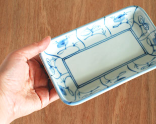 砥部焼・梅山窯　なずなの長方皿(5.2寸)を手に持って