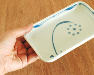 砥部焼・梅山窯　太陽柄の長角皿(5.2寸)を手に持って