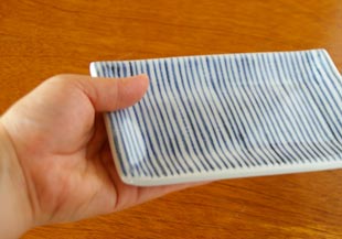 砥部焼・梅山窯　細とくさの布目角皿(5寸)を手に持って