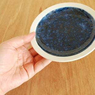 砥部焼・梅山窯　ごすうちの縁付皿(5寸)を手に持って