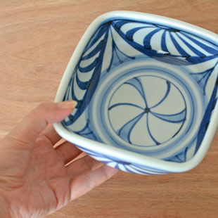 砥部焼・梅山窯　菊流れの四方鉢(5寸)を手に持って