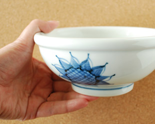 砥部焼・梅山窯　ひまわりの玉ぶち鉢(5寸)を手に持って