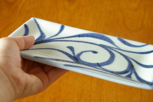 砥部焼・梅山窯　からくさの布目角皿（6,7寸）を手に持って