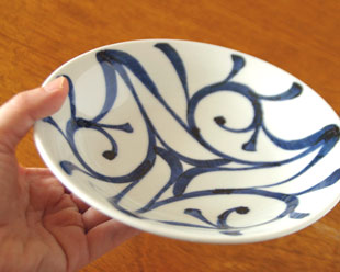 砥部焼・梅山窯　みつからくさの反深皿を手に持って