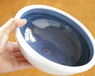 砥部焼・梅山窯　藍色の玉ぶち鉢（6寸）を手に持ったところ