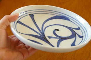 砥部焼・梅山窯　ひとつからくさの6寸皿を手に持って