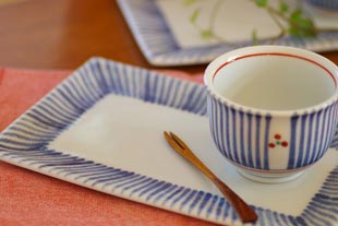 砥部焼・梅山窯　とくさ柄の布目角皿(7寸)に湯呑を乗せて