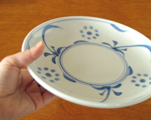 砥部焼・梅山窯　太陽柄の大皿を手に持って