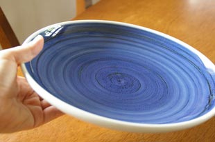 砥部焼・梅山窯　藍色の大皿（8寸）を手に持って
