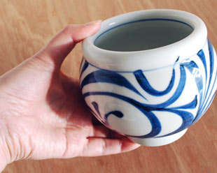 砥部焼・梅山窯　からくさの丸深鉢を手に持って