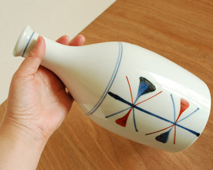 砥部焼・梅山窯　赤蝶文の花器を手に持って