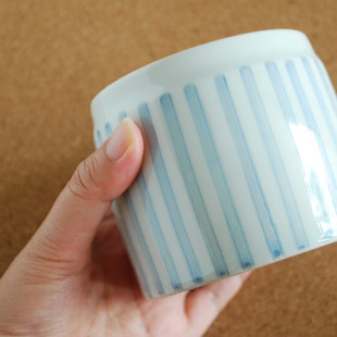 砥部焼・梅山窯　ストライプの筒ふた物を手に持って