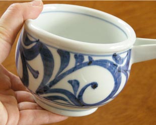 砥部焼・梅山窯　からくさの片口鉢（小）を手に持って