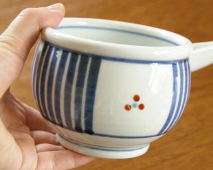 砥部焼・梅山窯　とくさみつ紋の片口鉢を手に持って