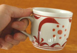 砥部焼・梅山窯　赤太陽のコーヒーカップを手に持って