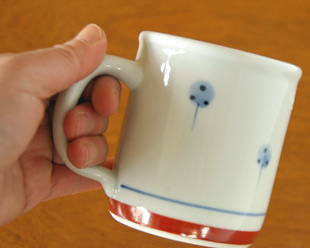 砥部焼・梅山窯　たんぽぽの切立マグカップを手に持って