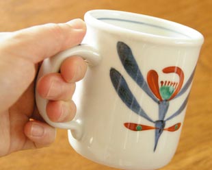砥部焼・梅山窯　あか花のマグカップを手に持って