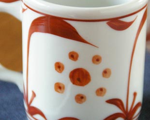 砥部焼・梅山窯　赤太陽のマグカップの絵付け
