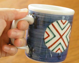 砥部焼・梅山窯　丸まどのマグカップを手に持って