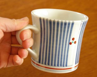 砥部焼・梅山窯 とくさみつ紋のマグカップを手に持って