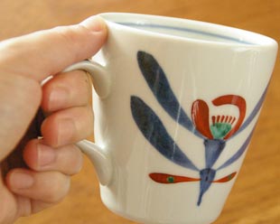 砥部焼・梅山窯　あか花のモーニングカップを手に持って