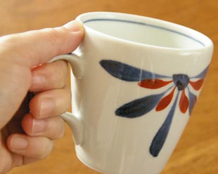 砥部焼・梅山窯 花もようのモーニングカップを手に持って