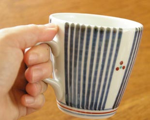 砥部焼・梅山窯　とくさみつ紋のモーニングカップを手に持って