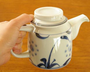 砥部焼・梅山窯　太陽柄のティーポットを手に持って