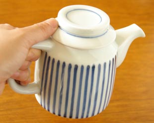 砥部焼・梅山窯　とくさ柄のティーポットを手に持って