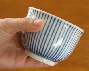 砥部焼・梅山窯　とくさ柄の湯呑を手に持って