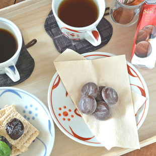 砥部焼・梅山窯　赤太陽のコーヒーカップのソーサーにお菓子を