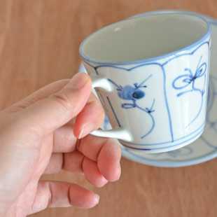 砥部焼・梅山窯　なずなのコーヒーカップを手に持って