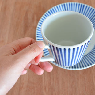 砥部焼・梅山窯　とくさ柄のコーヒーカップに紅茶をを手に持って