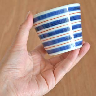 砥部焼・梅山窯　あい赤ラインのそばちょこを手に持って