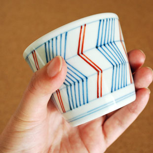 砥部焼・梅山窯　よろけ柄のそばちょこを手に持って