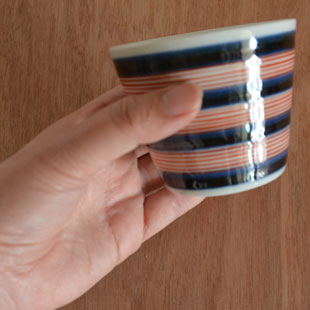 砥部焼・梅山窯　ごす細赤線のそばちょこを手に持って